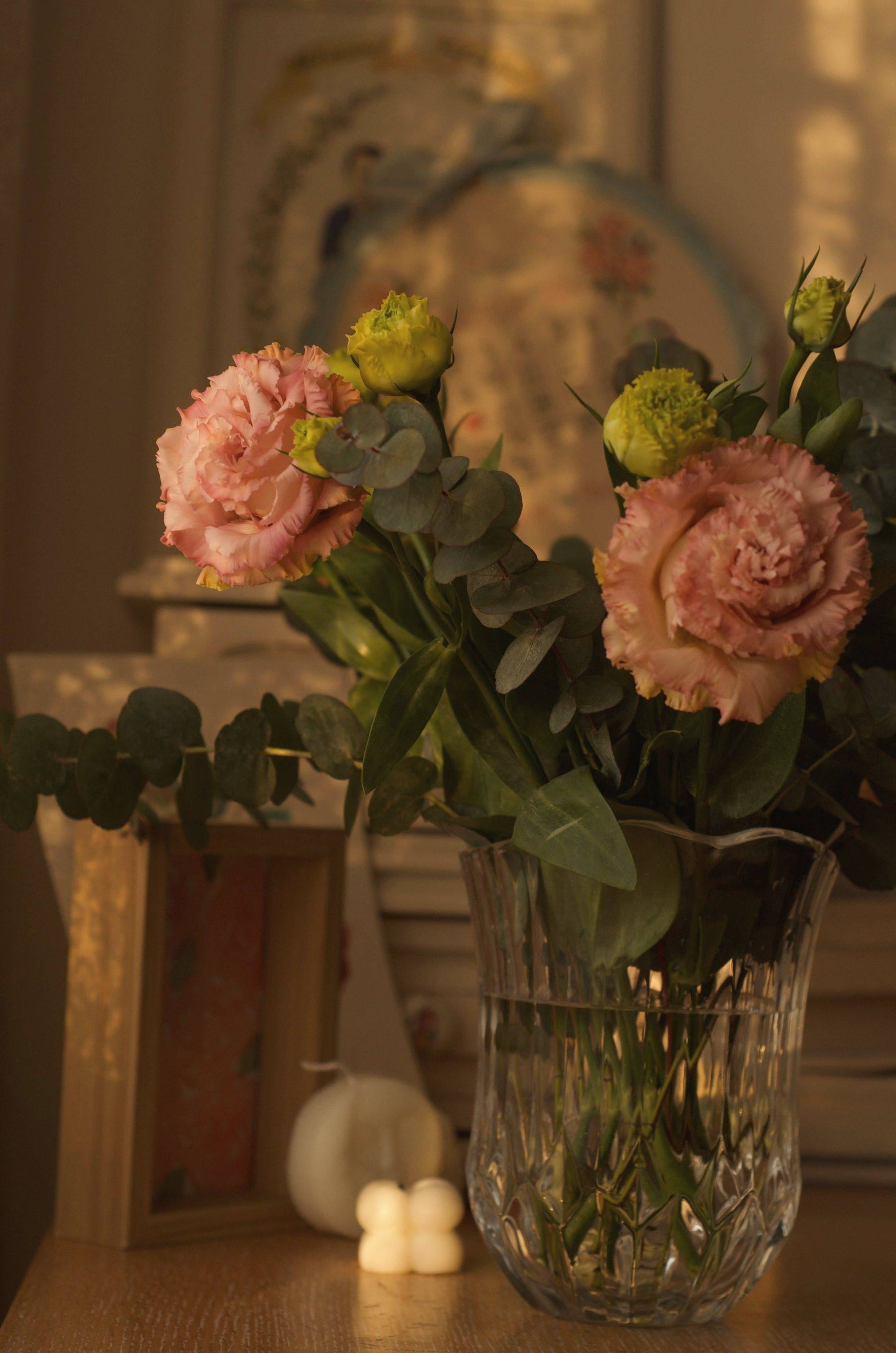 Peach roses in a crystal vase in warm evening light