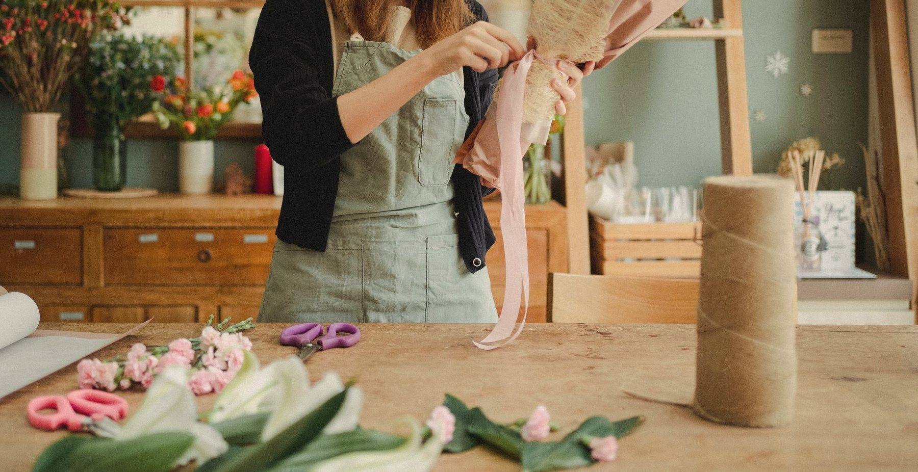 A workshop table laid with ribbon, twine and cut stems